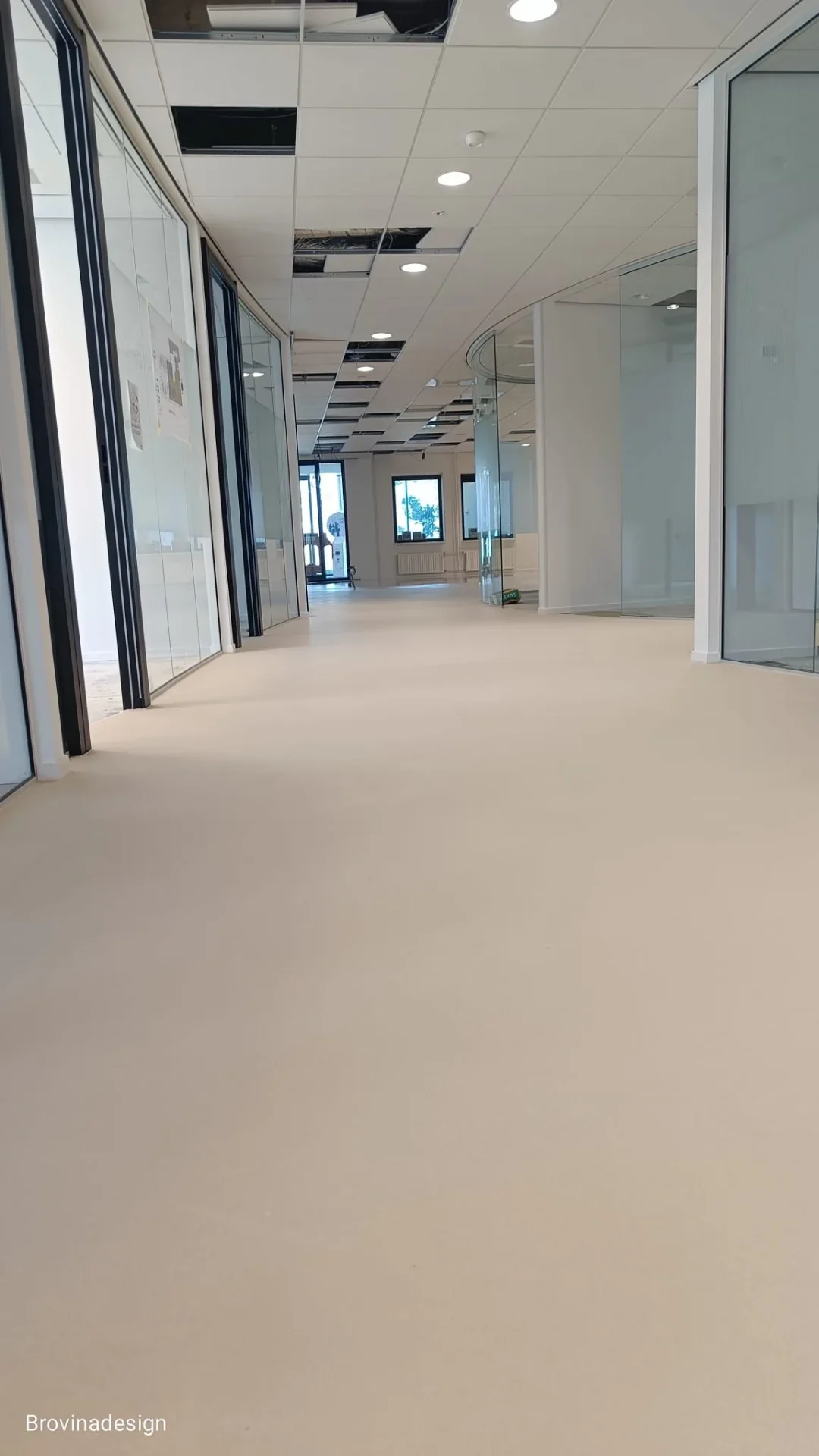 Beige gietvloer in kantoorruimte met glaswanden