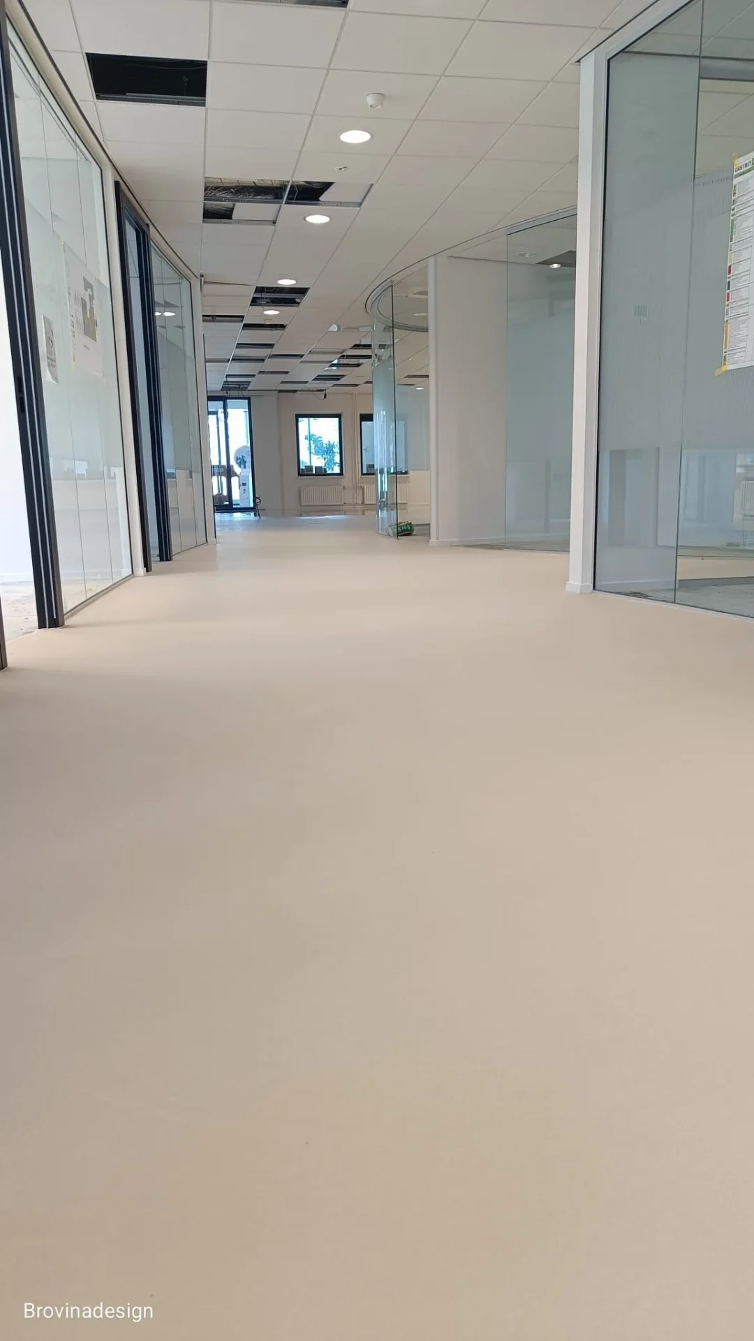 Beige gietvloer in kantoor met glaspartij