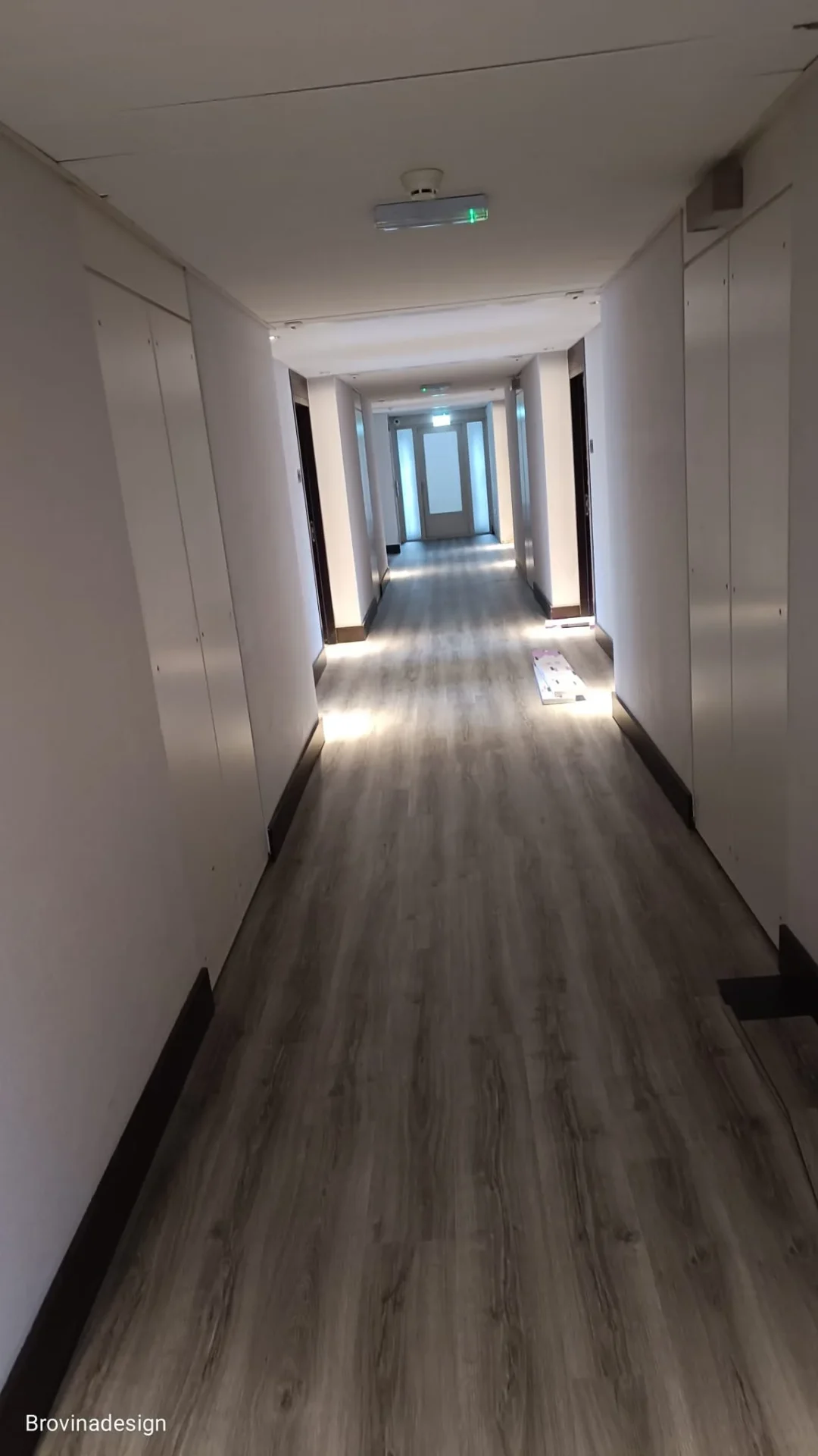 Donkere LVT vloer in hotelgang met LED-verlichting