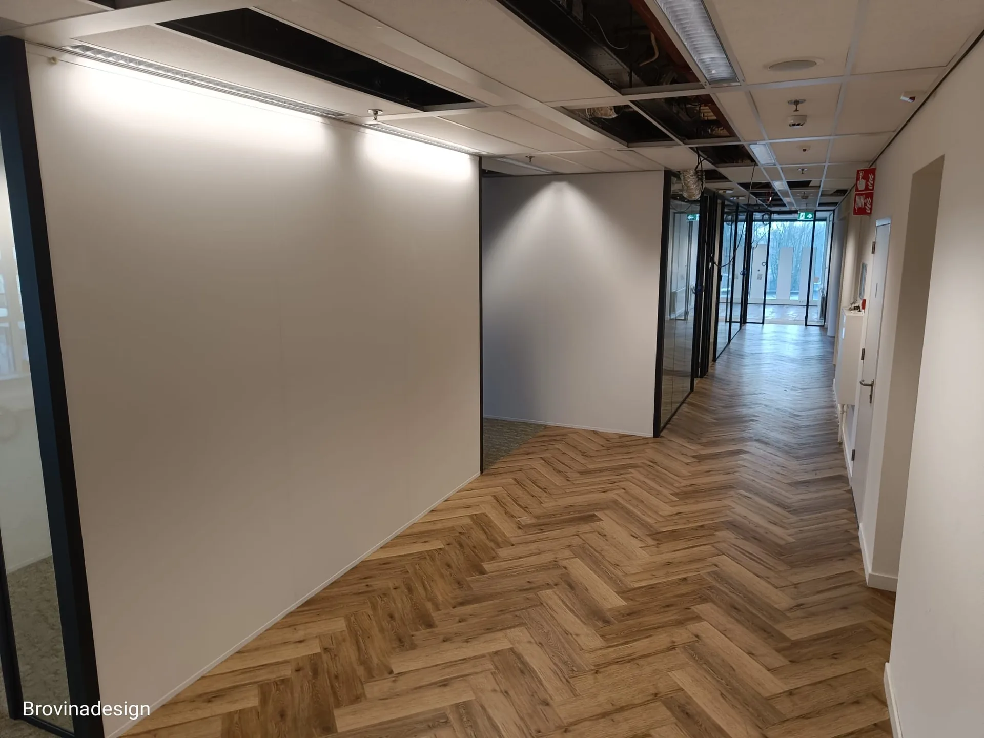 Visgraat-PVC kantoorgang langs grote glaspartij