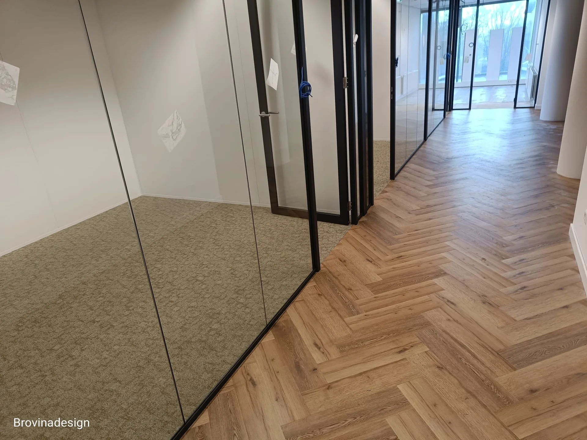 Strakke overgang van tapijttegels naar visgraat-PVC in modern kantoor